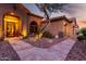 Inviting home entrance with stone pathway, desert landscaping, and a well-lit, arched doorway at 40619 N Candlewyck Ln, Phoenix, AZ 85086