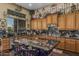 Expansive kitchen boasting black marble countertops, an island with seating, and custom cabinetry for ample storage at 40619 N Candlewyck Ln, Phoenix, AZ 85086