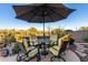 Cozy outdoor patio seating area with umbrella provides shade and comfort for entertaining or relaxing outdoors at 40619 N Candlewyck Ln, Phoenix, AZ 85086
