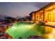 Backyard pool illuminated at dusk with stone accents and lush desert landscaping and a view of the home at 40619 N Candlewyck Ln, Phoenix, AZ 85086