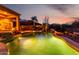Inviting backyard pool at dusk featuring desert landscaping, built-in spa and outdoor fireplace at 40619 N Candlewyck Ln, Phoenix, AZ 85086