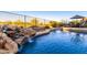 Gorgeous backyard pool featuring a rock waterfall, lush landscaping, and charming patio seating for ultimate relaxation at 40619 N Candlewyck Ln, Phoenix, AZ 85086