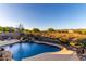 Sparkling pool area with rock waterfall, desert landscaping, and mountain views provides a tranquil escape at 40619 N Candlewyck Ln, Phoenix, AZ 85086