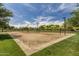 Sandy volleyball courts ready for a game under a bright sky, surrounded by a green lawn and mature trees at 40619 N Candlewyck Ln, Phoenix, AZ 85086