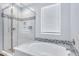 Modern bathroom with a glass-enclosed shower and tub, enhanced by tiled accents and natural light at 4332 E Boston St, Gilbert, AZ 85295