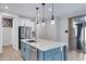 Kitchen island with stainless steel dishwasher and sink. White cabinets and refrigerator nearby at 4332 E Boston St, Gilbert, AZ 85295