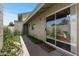 Backyard with lush landscaping, sliding glass door and a glimpse of neighborhood at 4502 W Continental Dr, Glendale, AZ 85308
