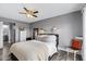 Bedroom featuring grey walls, ceiling fan, modern lighting, and a glimpse into the ensuite bathroom at 4502 W Continental Dr, Glendale, AZ 85308