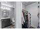 Walk-in closet showcasing ample storage, hanging racks, built-in shelving with bathroom view at 4502 W Continental Dr, Glendale, AZ 85308