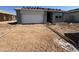 Under construction gray house with a two-car garage, driveway and freshly installed concrete border at 46869 W Old Timer Rd, Maricopa, AZ 85139