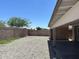 Large backyard featuring a covered patio area and a gravel landscape, enclosed by a brick wall at 4741 N 85Th Ave, Phoenix, AZ 85037
