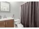 Bathroom showcasing a toilet, vanity with sink, and a stylish patterned shower curtain at 4741 N 85Th Ave, Phoenix, AZ 85037