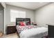 Bedroom with a bed featuring colorful pillows, laminate floors, and natural light at 4741 N 85Th Ave, Phoenix, AZ 85037