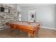 Spacious game room featuring a billiard table and a stone accent wall at 4741 N 85Th Ave, Phoenix, AZ 85037