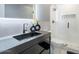 Modern bathroom featuring a sleek black vanity, white subway tile shower, and contemporary fixtures at 4748 E Redfield Rd, Phoenix, AZ 85032