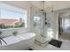 Bright bathroom with a soaking tub, corner shower, and a window with a neighborhood view at 4748 E Redfield Rd, Phoenix, AZ 85032