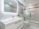Modern bathroom featuring a sleek vanity, illuminated mirror, and a glass-enclosed shower over tub at 4748 E Redfield Rd, Phoenix, AZ 85032