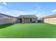 Spacious backyard featuring an outdoor dining area, covered patio and lush artificial grass at 48069 N Rico Way, Gold Canyon, AZ 85118