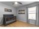 The Bedroom includes a dark wood crib, wood-look floors, and natural light at 48069 N Rico Way, Gold Canyon, AZ 85118