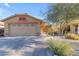 Charming home with a well-manicured front yard, a two car garage, and desert landscaping at 48069 N Rico Way, Gold Canyon, AZ 85118