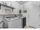 The bright laundry room has floating shelves and front-load machines at 48069 N Rico Way, Gold Canyon, AZ 85118