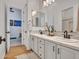 Bright bathroom featuring a dual sink vanity with modern faucets, and white cabinets at 4935 W Lariat Ln, Phoenix, AZ 85083