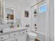 Bright bathroom featuring a white vanity, decorative mirror, and shower-tub combination with elegant gold fixtures at 4935 W Lariat Ln, Phoenix, AZ 85083
