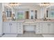 Bright bathroom featuring double sinks, sleek white cabinetry, and a contemporary design at 4935 W Lariat Ln, Phoenix, AZ 85083