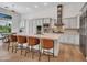 Bright kitchen featuring white cabinets, stainless steel appliances, a large island, and stylish bar stools at 4935 W Lariat Ln, Phoenix, AZ 85083