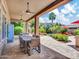 Covered patio features an outdoor dining table with seating and a view of the lushly landscaped backyard at 4935 W Lariat Ln, Phoenix, AZ 85083