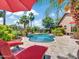 Beautiful backyard oasis with a sparkling pool, lounge chairs, and lush landscaping with mature palm trees at 4935 W Lariat Ln, Phoenix, AZ 85083
