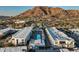 Aerial view showcases modern building with pool, palm trees, and beautiful mountain backdrop at 5455 E Lincoln Dr # 3006, Paradise Valley, AZ 85253