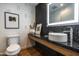 Modern powder room featuring dark vanity, decorative mirror, stylish wallpaper, and contemporary fixtures at 5455 E Lincoln Dr # 3006, Paradise Valley, AZ 85253