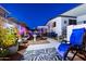 The cozy backyard offers relaxation with a patio chair, pavers, potted plants, and a white pergola at 5534 E Player Pl, Mesa, AZ 85215