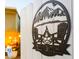 A close-up of a decorative backyard gate sign with mountain, chairs, and fire pit details at 5534 E Player Pl, Mesa, AZ 85215