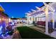 Cozy backyard with a covered patio, swing, turf lawn, and decorative string lights at 5534 E Player Pl, Mesa, AZ 85215