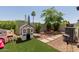 Charming backyard play area with artificial turf, a playhouse, and mature trees at 6196 E Calle Camelia --, Scottsdale, AZ 85251