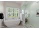 Bright main bathroom includes a freestanding tub, glass-enclosed shower with white tiling, and window views at 6196 E Calle Camelia --, Scottsdale, AZ 85251