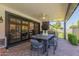 Covered patio featuring an outdoor dining area, ceiling fan, and access to the backyard through large glass doors at 6196 E Calle Camelia --, Scottsdale, AZ 85251