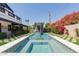 Inviting backyard pool with a waterfall feature, hot tub, and lush landscaping, offering a serene outdoor retreat at 6196 E Calle Camelia --, Scottsdale, AZ 85251