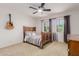 Cozy bedroom with a wooden bed frame, neutral decor and views from large windows at 6276 N 75Th Ln, Glendale, AZ 85303