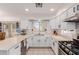 Bright kitchen features modern white cabinetry, neutral countertops and a view out of the window above the sink at 6276 N 75Th Ln, Glendale, AZ 85303