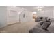 Open living room with neutral carpet, staircase and large sectional couch at 6276 N 75Th Ln, Glendale, AZ 85303