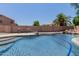 Backyard pool featuring a rock waterfall, surrounded by desert landscaping and privacy walls at 6276 N 75Th Ln, Glendale, AZ 85303