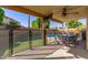 Spacious covered patio area with ceiling fan, offering a comfortable outdoor living space overlooking the pool at 6430 E Riverdale St, Mesa, AZ 85215