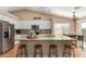 Open kitchen features granite countertops, modern stainless appliances, white cabinetry and a breakfast bar with seating at 6430 E Riverdale St, Mesa, AZ 85215