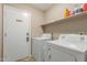 Functional laundry room features a full size washer and dryer and ample shelf space for storage at 6430 E Riverdale St, Mesa, AZ 85215