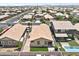 An aerial view shows a neighborhood with well-maintained homes, green lawns and a community pool at 7440 E Osage Ave, Mesa, AZ 85212