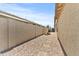 Long backyard featuring gravel path, retaining wall, and a planting bed along the side of the property at 7440 E Osage Ave, Mesa, AZ 85212