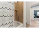 Well-lit bathroom showcases tiled shower/tub, toilet, and doorway leading to bedroom with blue wall and wood flooring at 7440 E Osage Ave, Mesa, AZ 85212